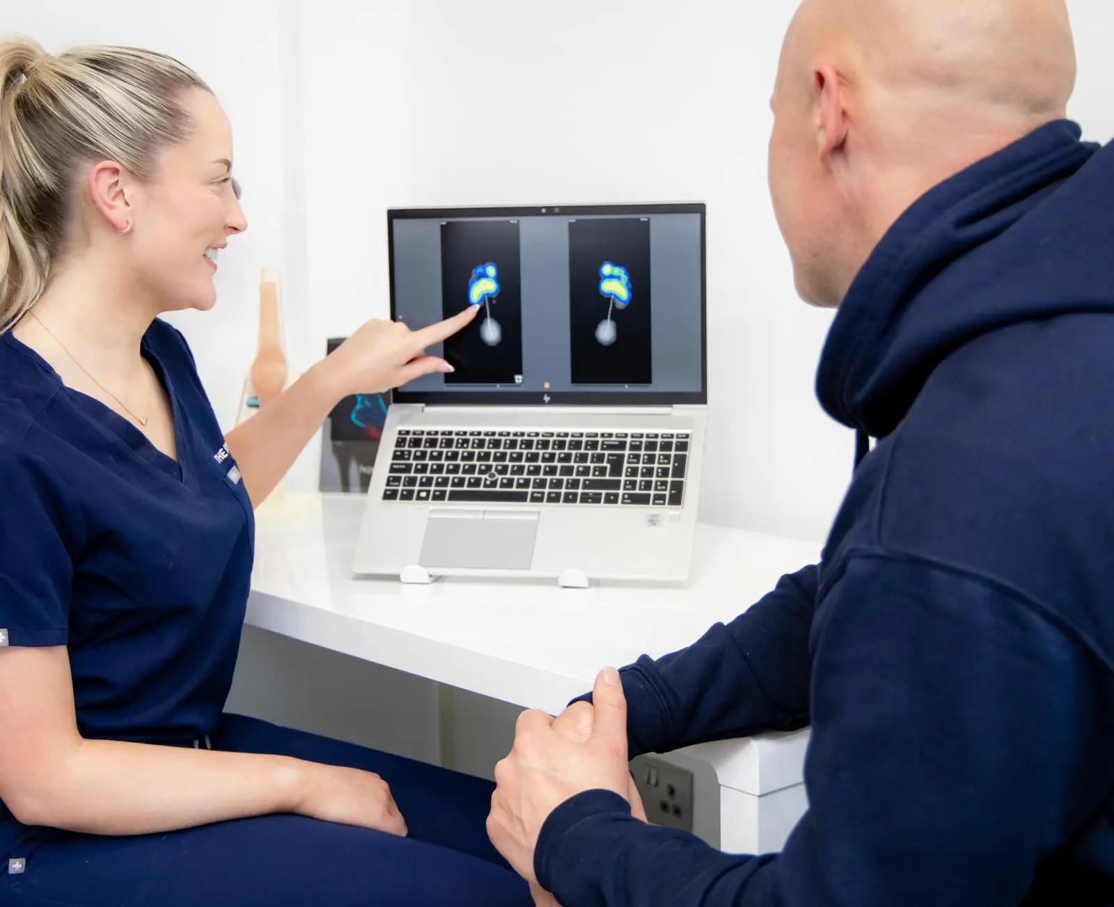 Podiatrist in blue gloves treating hard skin on a patient’s sole at The Foot Lab podiatry clinic in Glossop